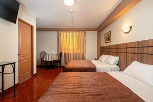 利马波希米亚酒店的酒店客房设有两张床和一张桌子。