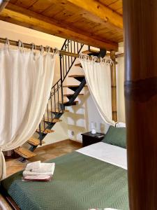 夏卡B&B Antico Caricatore - Ex B&B Porta di Mare的一间卧室配有带窗帘的床和楼梯