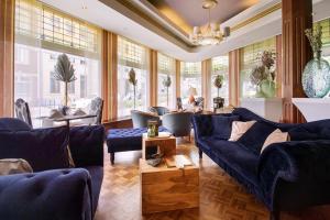 法尔肯堡单极大酒店的客厅设有蓝色的沙发和窗户。