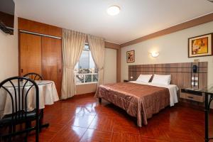 利马波希米亚酒店的一间卧室配有一张床、一张桌子和一个窗户。