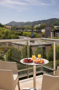 圣塞瓦斯蒂安Hotel Antik San Sebastián的阳台上的一张桌子上放着两盘水果
