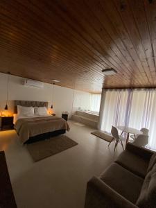 圣博尼法西乌Pousada Dona Teresinha的一间卧室配有一张床、一张桌子和一张沙发
