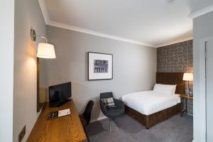 格拉斯哥Glasgow West Hotel by Compass Hospitality的配有一张床和一张书桌的酒店客房