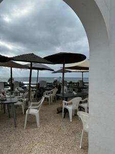 达布阿扎Beach House的海滩上一组桌椅和遮阳伞