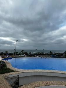 达布阿扎Beach House的一个蓝色的大型游泳池,背景是大海