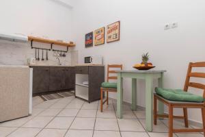 拉加纳斯Dora's Apartments的厨房配有桌子、两把椅子和台面