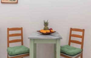 拉加纳斯Dora's Apartments的一张桌子,上面放着一碗水果,上面放着两把椅子