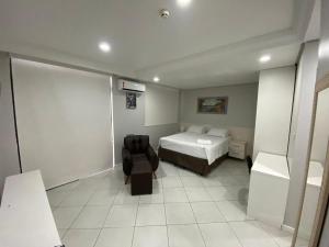 马瑙斯Millenium Hotel Flat的一间卧室配有一张床和一把椅子