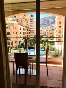 蒙特卡罗Monaco Fontvieille Port - refined apartment overlooking garden - open air swimming-pool的阳台景餐桌