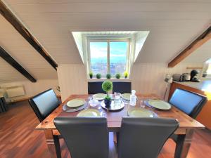 特隆赫姆Sunset Penthouse, Fjord View & Parking的一间带桌椅和窗户的用餐室
