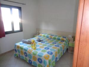维耶斯泰Village La Canzone del Mare的一间卧室配有一张黄色和蓝色毯子的床
