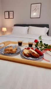 亚历山德鲁波利斯Hermes Modern Apartment的床上装有两盘食物的托盘