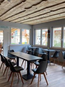 托考伊Demizson Vendégház的用餐室设有桌椅和窗户。