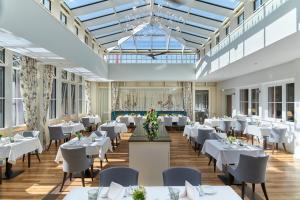 施托尔贝格哈尔茨Naturresort & Spa Schindelbruch的一间设有白色桌椅的用餐室