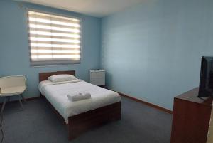 梅希约内斯HOTEL 507 INN的蓝色的卧室设有床和窗户