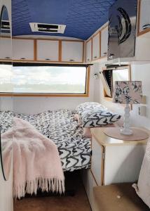 赫尔辛基Lissu Love Mobil的小房间设有一张床和一张带台灯的桌子