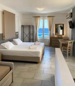 梅加斯·亚洛斯-奈特斯Agnadi Syros Beachfront Studios & Rooms的一间带两张床的卧室,享有海景