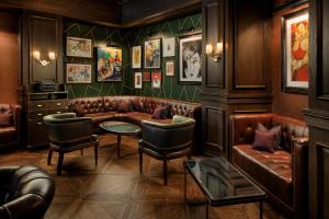 纽约Mandarin Oriental, New York的酒吧配有皮沙发、桌子和椅子