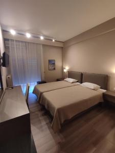 亚历山德鲁波利斯Plaza Hotel的酒店客房设有两张床和电视。
