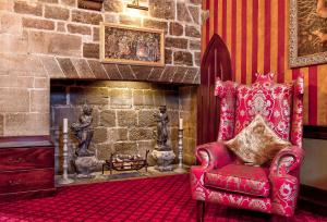 赫克瑟姆兰利城堡酒店的客厅设有红色椅子和壁炉