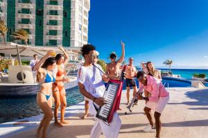 坎昆Sandos Cancun All Inclusive的一群人在海滩上玩手风琴