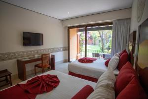 库埃纳瓦卡Hosteria Las Quintas Hotel Restaurante Bar的酒店客房设有两张床和电视。