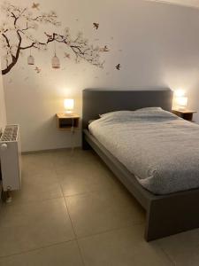 艾瓦耶Au Paradis d'Ayli的卧室配有一张床铺,墙上挂着一棵树