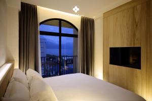 Dahan春沐七星潭海岸旅店的一间卧室设有一张床和一个阳台的窗户。