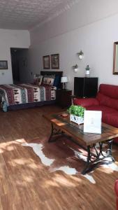 汤姆斯通Katie's Cozy Suites的客厅配有红色的沙发和桌子