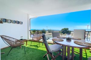 萨贡托Casa frente al mar con piscina privada的阳台的用餐室配有桌椅