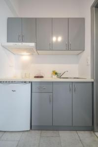 纳克索乔拉Luxury Naxos Apartment | Deluxe Triple Studio | 150m From St. George Beach | City Center | Saint George的厨房配有白色橱柜和水槽