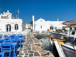 纳克索乔拉Luxury Naxos Apartment | Deluxe Triple Studio | 150m From St. George Beach | City Center | Saint George的海港里一群蓝色的椅子和船