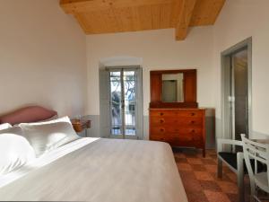 拉吉乌斯蒂尼阿纳艾卡萨利德尔皮诺酒店的一间卧室配有一张床、梳妆台和镜子