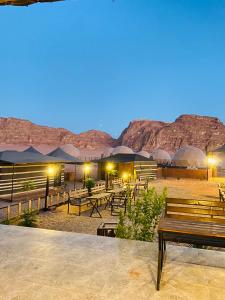 瓦迪拉姆Faisal Wadi Rum camp的沙漠中的一组长椅和桌子