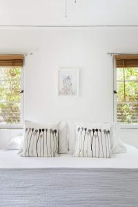 洛杉矶Silver Lake Mid-century Nestled In The Treetops的白色卧室配有白色床和白色枕头