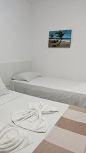 塔曼达雷Pousada Solar da Praia的一张白色的床,上面有一条毛巾