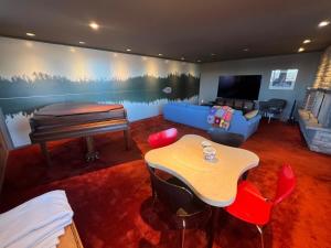 明尼阿波利斯Mid-Century Lakefront Haven Near Wayzata的一间配备有桌子、沙发和电视的客房