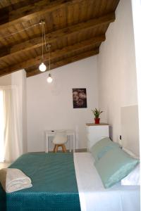 波利卡IL CORTILE DELLE ZAGARE的一间卧室配有绿色的床和椅子