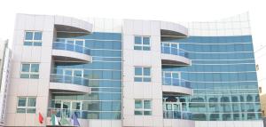 迪拜阿拉玛公寓酒店的一座高大的玻璃建筑,拥有蓝色的窗户