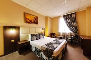 克拉斯诺达尔Marton Severnaya Krasnodar的酒店客房配有一张床铺和一张桌子。