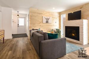 圣弗朗索瓦小河Le Loonix- Chalet familiale avec Spa的带沙发和壁炉的客厅