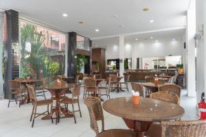 马塞约Ritz Plazamar Hotel的大楼内带桌椅的餐厅