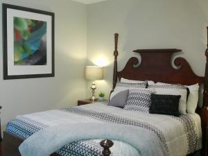 斯普林莱克Fayetteville Studio 415的一间卧室配有一张大床和木制床头板