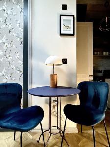 布莱顿霍夫Central Brighton Stylish Studio Apartment的一张桌子和两张蓝色椅子