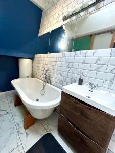 布莱顿霍夫Central Brighton Stylish Studio Apartment的一间带水槽、浴缸和卫生间的浴室