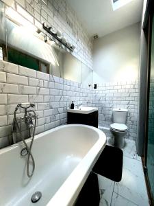 布莱顿霍夫Central Brighton Stylish Studio Apartment的白色的浴室设有浴缸和卫生间。