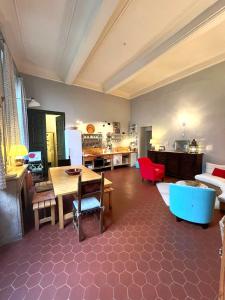 阿维尼翁Palais des Papes - Spacious Historic Apartment in Private Mansion ! Free PARKING Nearby ! Spacieux Appartement Historique dans Hôtel Particulier ! PARKING à proximité Offert !的一个带桌子和厨房的大客厅