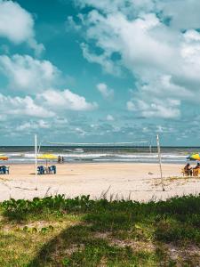 蒙加瓜Casa Do Mar - Wi-fi - Netflix - Piscina的海滩上设有椅子和遮阳伞,还有大海