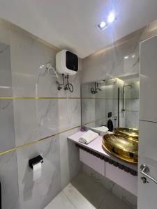 阿布贾Austra Villa Maitama Abuja的浴室设有金色水槽和镜子