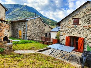 波泰皮莫朗Montagne Ski Porté Puymorens GÎTE的石头建筑前的野餐桌